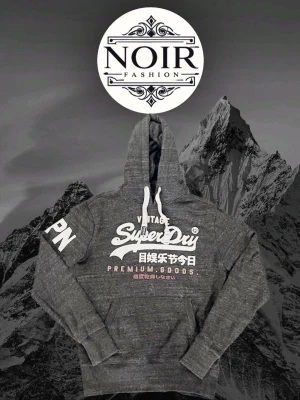 Mörkgrå Superdry hoodie med tryck - Säljer denna sällsynta och mycket eftertraktade Superdry hoodien | Passar 180-190 | Mycket bra skick | Vid eventuella frågor hör gärna av dig och erbjuder bra pris vid köp av bundle😁✅