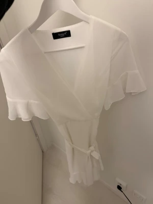 Vit klänning från sisters point - Vit klänning med volanger & knytband på sidan från sisters point