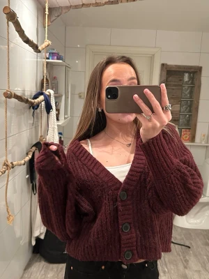 Vinröd kofta med knappar - Mörkröd stickad kofta från Stories i storlek M. Är i ett mycket bra skick, finns inte några noppror. Köpt för 179 kr.
