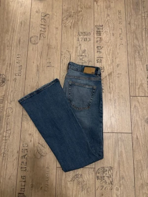 Blå bootcut low waist jeans från lager 157  - Klassiska blå Levi's jeans i bootcut-modell med fem fickor och snygga kontrastsömmar. Jeansen har en mellanblå tvätt och är tillverkade i slitstark denim. Perfekta för dig som gillar en tidlös och avslappnad stil.