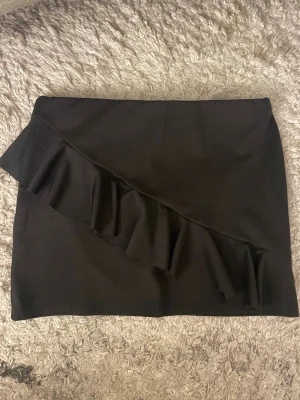 Svart kortkjol med volangdetalj - Inga defekter 