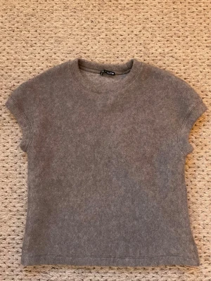 Stickad topp - Mysig grå stickad topp från Zara med rund halsringning och korta ärmar. Enkel och stilren design. 