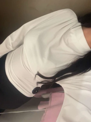 Vit långärmad croppad topp - Säljer en stilren vit långärmad topp med croppad passform och hög hals. Toppen har vida ärmar och sitter tight över kroppen, vilket ger en snygg siluett. Perfekt att matcha med jeans eller kjol för en trendig look.