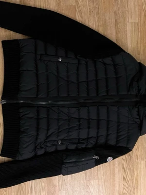 Moncler Cardigan - Säljer en schysst Moncler cardigan då den börjar sitta lite tajt. Det är en populär och klassisk padded zip-up cardigan. Som är i väldigt bra skick då den är sparsamt använd så inga tecken på slitage eller likande. Jackan är i stl L (IT50)  Vid fråger eller likande är de bara att höra av sig.                                                            Priset är ej hugget i sten!