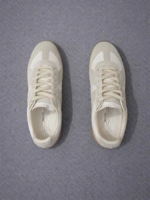 Maison margiela gats - Snygga sneakers i vitt och ljusgrått med ovandel i mocka och skinn. Klassisk design med rund tå och platt sula i gummi. Perfekta för dig som gillar stilrena och tidlösa sneakers med en modern touch.