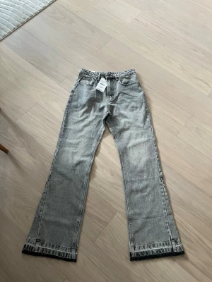 Grå straight jeans från Zara - Snygga grå jeans från Zara i rak modell med klassisk femficksdesign och bälteshällor. Jeansen har en cool tvättad look och är tillverkade i bomull. Perfekta för en avslappnad och trendig stil.