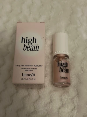 High Beam highlighter från Benefit - High Beam highlighter från Benefit i nyansen satinrosa. Ger en skimrande, ljusrosa glow till huden och har en flytande formula som är lätt att applicera.