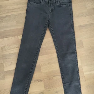 Grå skinny jeans W29 L32 - Säljer ett par grå skinny jeans i klassisk femficksmodell. Jeansen har smal passform hela vägen ner och är tillverkade i stretchigt jeanstyg för extra komfort. Perfekta för dig som gillar en tight look och vill ha ett par stilrena jeans i garderoben.