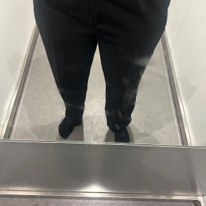 Svarta kostymbyxor i storlek 38 - Säljer ett par svarta kostymbyxor i storlek 38. Byxorna har rak passform med klassisk midja och är tillverkade i ett mjukt tyg som ger en clean look. Perfekta för dig som gillar stilrena och enkla plagg.