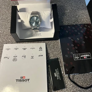 Tissot PRX herrklocka – 1 år gammal med originalkartong - Beskrivning:   Säljer min Tissot PRX herrklocka i stainless steel med ljusblå urtavla. Klockan har använts i cirka ett år och är i gott skick. Levereras komplett med originalkartong och manual. Klassisk och stilren m