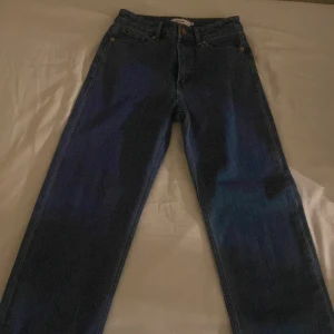 Blå raka jeans från Stylein - Klassiska blå jeans från Stylein med rak passform och normal midja. Jeansen har fem fickor, gylf med dragkedja och knapp samt bälteshällor. Tillverkade i robust denim som ger en tidlös look. Perfekta för dig som gillar enkel och clean stil.