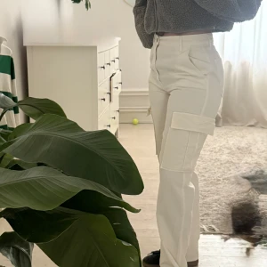 Ljusa cargopants i 100%  bomull - Snygga vita cargopants från STR med hög midja och raka ben. Byxorna har stora fickor på sidorna och är tillverkade i 100% bomull. Endast testade hemma. 