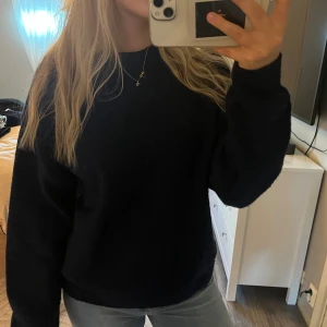 Mörkblå stickad tröja - En enkel och stilren mörkblå stickad tröja med rund halsringning och långa ärmar. Tröjan har en klassisk passform och ribbade muddar vid ärmslut och nederkant. Perfekt att slänga på sig när det är kyligt ute.