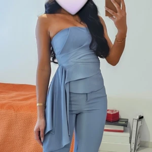 Ljusblå kostymbyxor med en snygg topp set - Säljer en snygg ljusblå kostymbyxor med axelbandslös överdel och draperad detalj i midjan. 