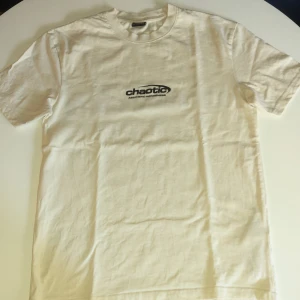 Vit Graphic t-short S- XXS - Helt ny vit t-shirt  i relaxed fit med svart tryck 'chaotic aesthetic awareness' fram och stort tryck på ryggen. Mjuk bomullskvalitet och klassisk rund hals. Perfekt för dig som gillar streetwear och grafiska prints.