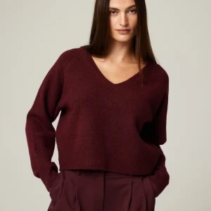 Vinröd stickad v-ringad tröja - Mysig vinröd stickad tröja med v-ringning och avslappnad passform. Tröjan har långa ärmar och ribbade muddar vid ärmslut och nederkant. Perfekt för lager-på-lager under kyliga dagar.