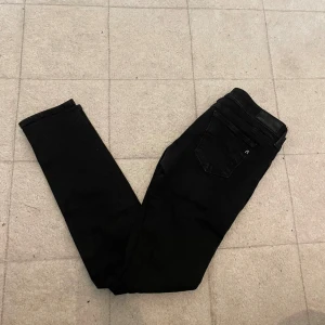 Svarta replay jeans  - Snygga svarta skinny jeans med klassisk femficksdesign och smal passform. Perfekta för dig som gillar en stilren look och vill ha ett par byxor som sitter tajt hela vägen ner. Passar till allt och är ett måste i garderoben.