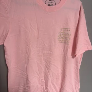 Rosa Anti Social Social Club t-shirt - Säljer en rosa t-shirt från Anti Social Social Club med tryck både fram och bak. T-shirten är i 100% bomull och har en klassisk passform med korta ärmar. Perfekt för dig som gillar streetwear och vill sticka ut med en snygg färg.