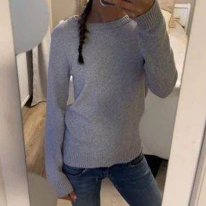 Ljusgrå stickad tröja - Enkel och stilren ljusgrå stickad tröja med rund halsringning. Långärmad och mjuk.