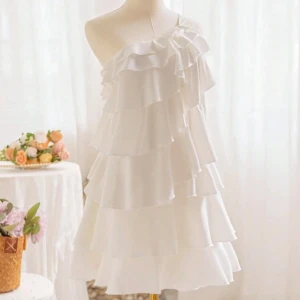 Vit omlottklänning med volanger - Jättefin studentklänning!!!💗Supersöt vit kortklänning volanger och asymmetrisk axelbandslös design. Klänningen har en omlott-look med ett axelband och passar allt mellan xxs-m, den är väldigt stretchig! Skriv vid frågor💗