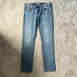Ljusblå jeans - Snygga ljusblå skinny jeans med klassisk femficksdesign och diskreta slitningar på benen. Jeansen har normal midja och är tillverkade i stretchigt denim för en bekväm passform. Perfekta till sneakers eller boots. Slim jeans i storlek 33/32