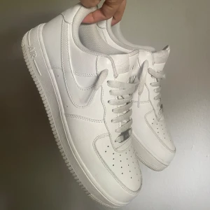 Nike Air Force 1 helvita sneakers - Vita Nike Air Force 1 sneakers, storlek 44, väldigt bra skick, inga creases och använda max 10 gånger. Säljer då dom inte passar min stil längre:)