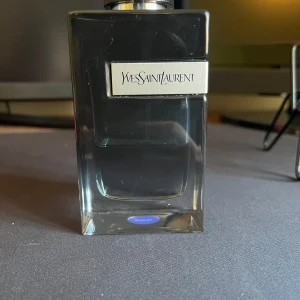 Yves Saint Laurent parfymflaska ungefär 40 ml kvar - Stilren parfymflaska från Yves Saint Laurent med modern design. Perfekt för dig som vill ha en ikonisk accessoar på hyllan. Volym och ingredienser syns ej på bilderna.