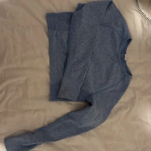 Blå långärmad träningströja från Divina - Superskön blå långärmad träningströja från Divina med tumhål i ärmsluten och snygga stickade detaljer på sidorna och ärmarna. Använt 2 gånger 