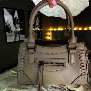 Beige Gina väska - Snygg Gina väska, nypris 399 använd en gång o tillkommer ett långt band