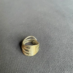 Bred handgjord ring - 16.0 cm bred ring i silver med en cool design. Ringen har flera tunna band som slingrar sig runt fingret och ger ett edgy uttryck. Perfekt för dig som gillar statement-smycken och vill sticka ut lite extra.