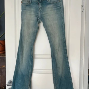 Bootcut jeans från Blend, ljusblå - Ljusblå bootcut jeans från Blend med klassisk femficksdesign och snygga slitningar. Jeansen har broderade bakfickor. 