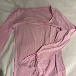 Ljusrosa långärmad topp från Gina Tricot - Supersöt ljusrosa långärmad topp från Gina Tricot med rundad, djup urringning. Lappen är avklippt men tröjan är i storlek xs 