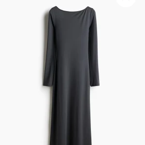 Svart långklänning med öppen rygg H&M - Svart långklänning från H&M i mjuk och stretchig polyesterblandning. Klänningen har lång ärm, rund halsringning och en snyggt öppen rygg som ger en extra touch. Enkel och stilren design som sitter snyggt på kroppen.