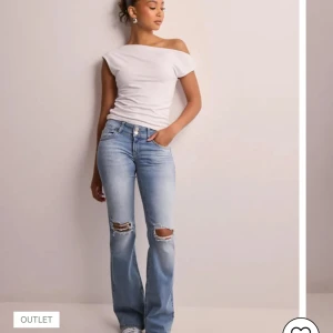 Ljusblå bootcut jeans med slitningar - Snygga ljusblå jeans med bootcut passform och slitna detaljer över knäna. Jeansen har klassiska fickor fram och bak, samt dubbla knappar i midjan. Perfekta för en avslappnad och trendig look. Pris kan alltid diskuteras! ❤️Inga skador alls, fint skick! 