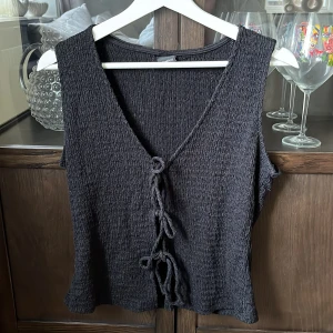 Svart topp med knytband - Säljer en svart topp med knytband framtill från Gina Tricot. Köpt på Vinted men kommer inte till användning. Väldigt fin 🫶🏽