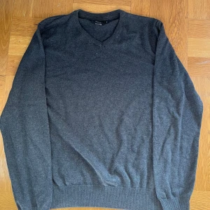 Sweatshirt  - Mörkgrå v-ringad tröja från South West i storlek S. Tröjan har långa ärmar, ribbade muddar och en klassisk passform. Perfekt för lager-på-lager och enkel att matcha med jeans