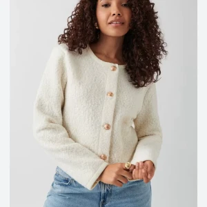 Vit kofta med guldknappar från Gina Tricot - Superfin vit kofta från Gina Tricot med rund halsringning och dekorativa guldiga knappar framtill. Koftan är stickad i ett fluffigt material och har långa ärmar. Skriv för fler bilder. Stolek XS💕prislappen är kvar.