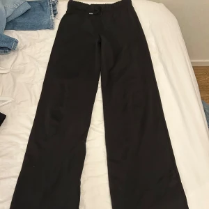 Svarta vida byxor med snörning - Svarta mjukisbyxor med vida ben och elastisk midja med snörning. 