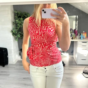 Röd mönstrad topp - Ärmlös vintage från Esprit i rött och vitt med coolt abstrakt mönster. Toppen har rund halsringning och ett knytband i midjan som ger en fin form. Står storlek M på lappen men sitter som S.