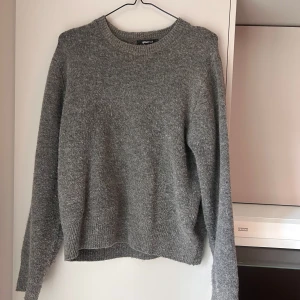 Grå stickad tröja från Gina Tricot - Mysig grå stickad tröja från Gina Tricot med rund halsringning och ribbade muddar. Knappt använd.