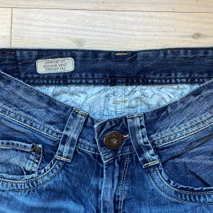 Lågmidjade Pepe jeans - Supersnygga jeans i en perfekt blå färg från märket Pepe jeans. I jeansen står det (första bild) regular waist men de är ett av de mest lågmidjade jeans jag provat. Jag har aldrig använt jeansen men köpt på sellpy - där stod det mycket bra skick men har små skador vid bakfickakanten (se två sista bilderna). Ovansett så jeans i ett bra stark denim tyg. I byxorna står det w28 och l32. Storlek xs/s (längd passar någon runt 160, midjan blir mer lågmidjat om du är mindre).
