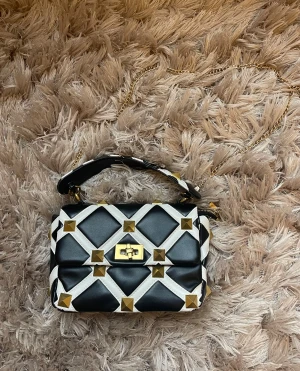 Väska med nitar - Svart vit Crossbody väska i läder med guldfärgade nitar, några defekter som syns på bilderna 