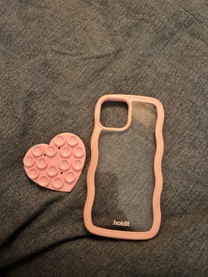 Mobil skal och plupp hjärta till💗 - Rosa skal till IPhone 12, fint skal från Holdit med hjärtpluppar till som också kommer från Holdit.