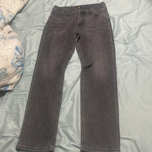 Grå jeans från Lee - Snygga grå jeans från Lee med en klassisk straight passform. De har en normal midja och är perfekta för en avslappnad stil. Jeansen har en dragkedja och knapp framtill.