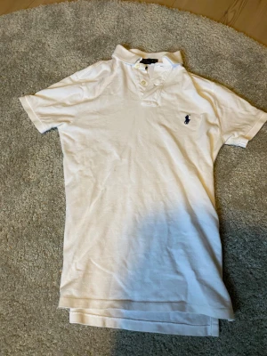 Vit pikétröja från Polo Ralph Lauren XS - Vit pikétröja från Polo Ralph Lauren i modellen Custom Slim Fit köpt direkt från NK. Med ett riktigt bra skick och inte använd många gånger.Tveka inte att skriva om ni har några frågor!