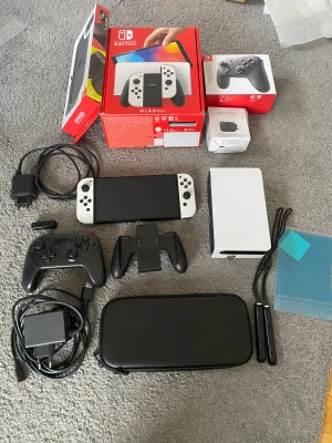Nintendo Switch OLED - Mycket bra skick, knappt använt. Inga repor på skärmen+ skärmskydd. Nintendo switch OLED med tillbehör. Inkluderar dockningsstation, joy-cons, extra handkontroll, hdmi sladd, fodral, extra skärmskydd samt adapter. 128GB SD kort ja som sitter i. Skickas i original förpackningar