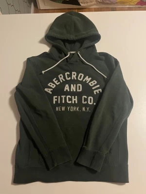 Abercrombie & fitch hoodie mörkgrön XS - Abercrombie & fitch hoodie i mörkgrön färg. Storlek XS passar 164-174 cm lång. I helt perfekt skick som ny. Riktigt snygg och perfekt inför vintern. Kolla gärna in mina andra annonser för mer snygga kläder och rabatt vid köp av flera 😃