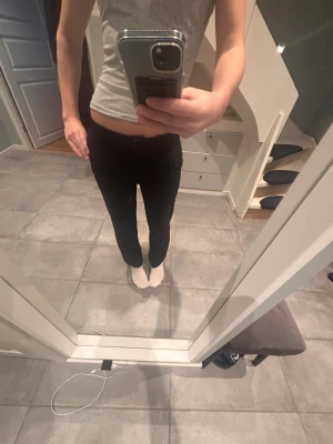 Kostymbyxor low/mid waist - Supersnygga svarta kostymbyxor i rakt ben med en stilren och tidlös passform. Sitter fint över höften och faller rakt ner längs benen. Perfekta både till skola, jobb och festligare tillfällen.