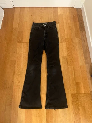 Svarta bootcut jeans från Cubus i storlek XS/30 - Svarta jeans från Cubus i bootcut-modell, storlek XS/30. Snyggt utsvängda ben och klassisk femficksdesign. Jeansen har knapp och dragkedja framtill och jeansen är väldigt stretchiga vilket är jätte skönt.