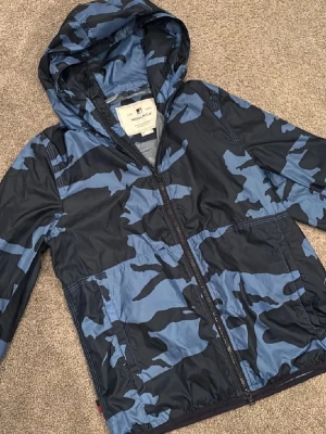 Woolrich vindjacka - Sjukt snygg och eftertrakad vindjacka från Woolrich i blått och svart camomönster. Storlek M